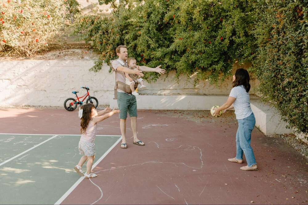 Family playing at a tennis court together