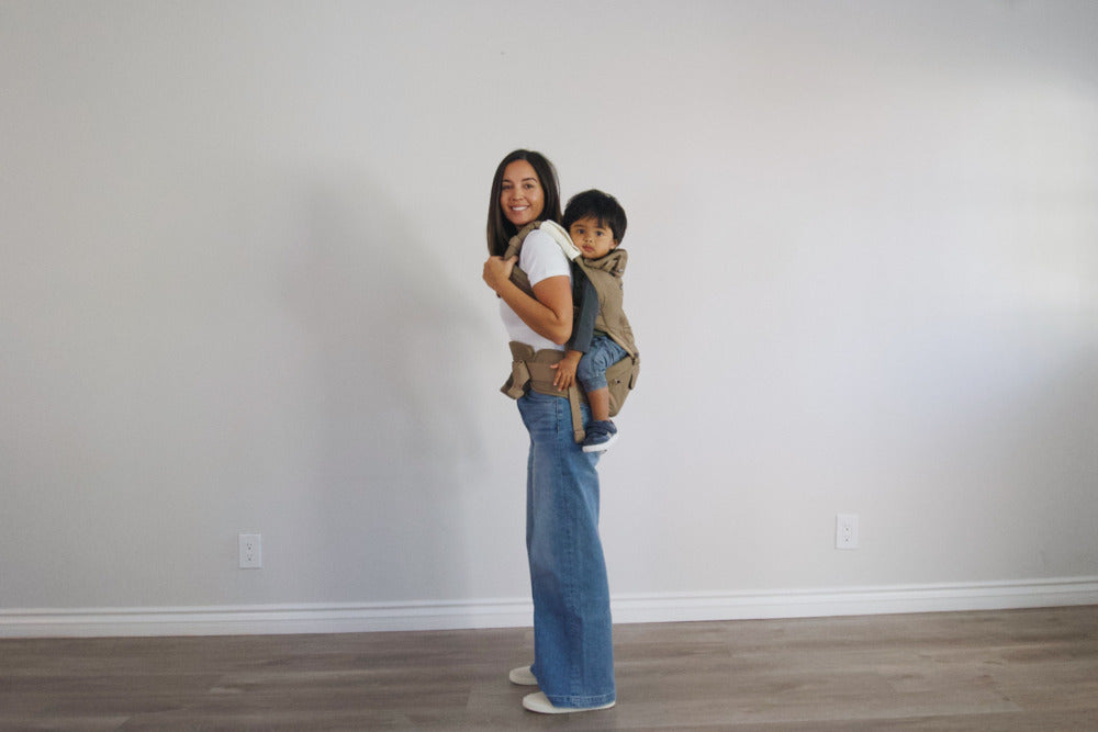 Mom carrying baby in best baby carrier for bad back